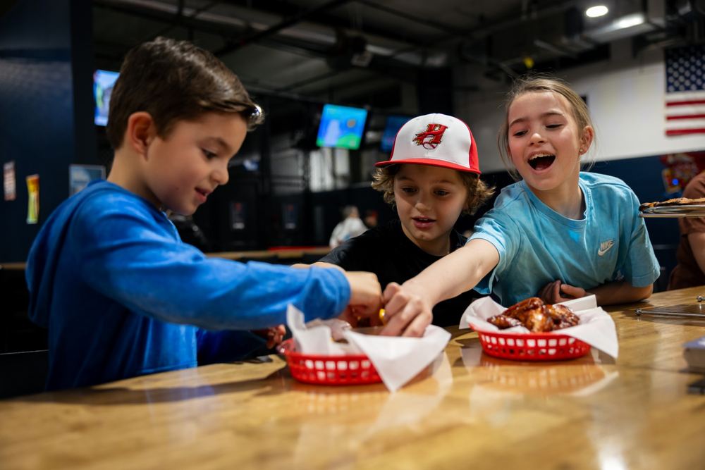 Kids sharing wings at Hitters